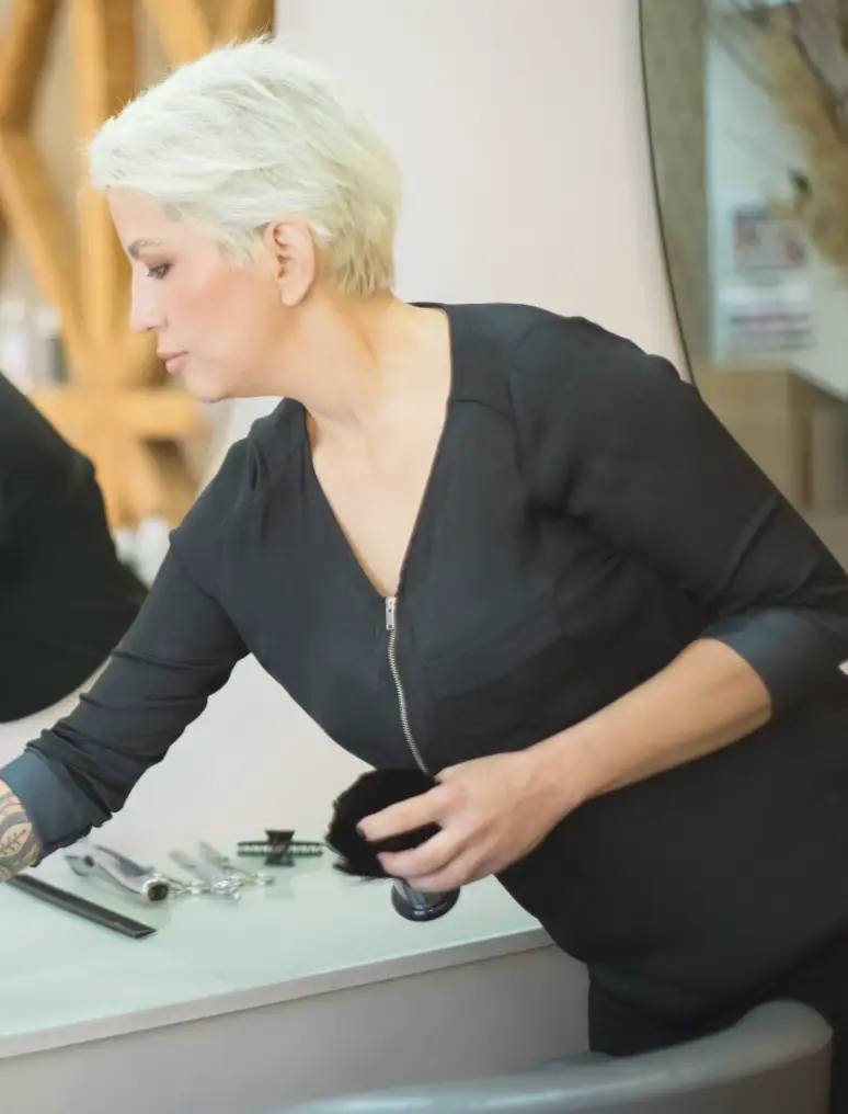 A salon owner setting out tools at her station