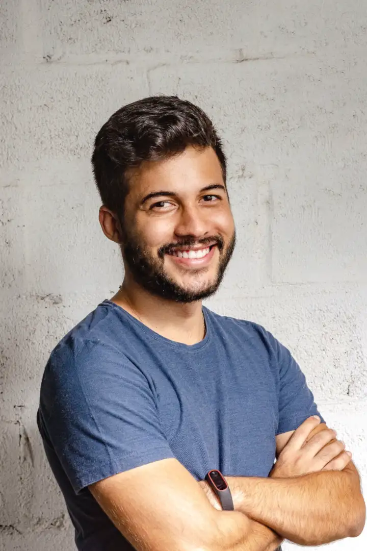 Dario M., owner of a bike shop, arms crossed by a whitewashed wall