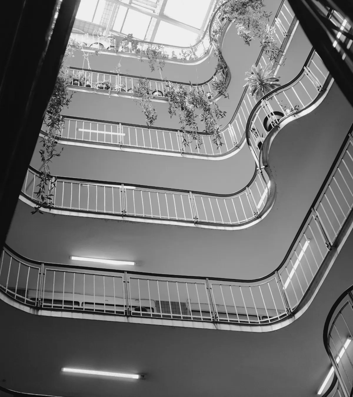 Looking up through the curved balconies of a bright, many-storied atrium