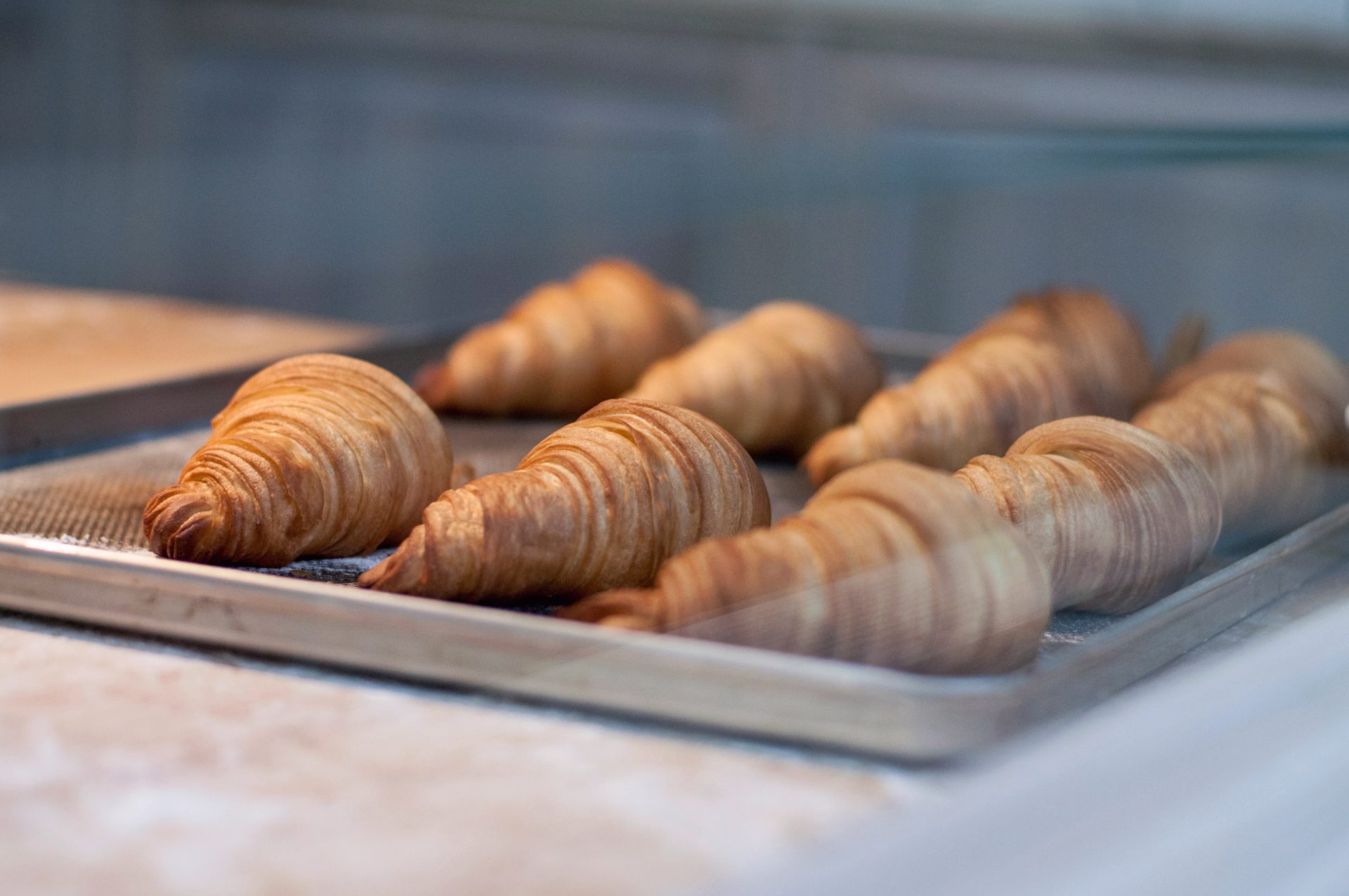 A tray of freshly baked butter croissants with deep golden, flaky layers.