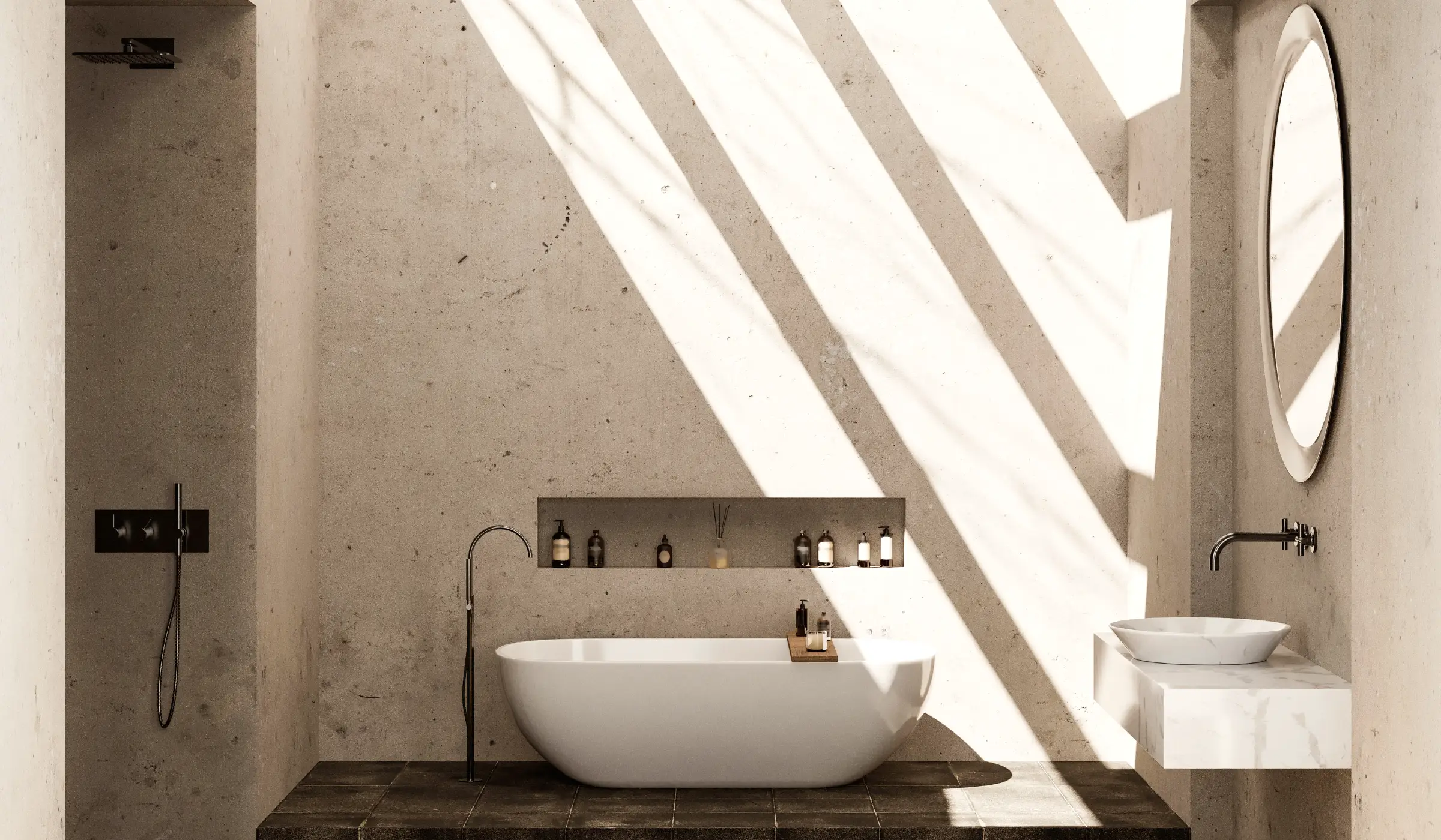A remodeled bathroom in limewashed concrete: a stone tub on a dark tile plinth, a floating marble basin and an oval mirror, striped by afternoon sun.