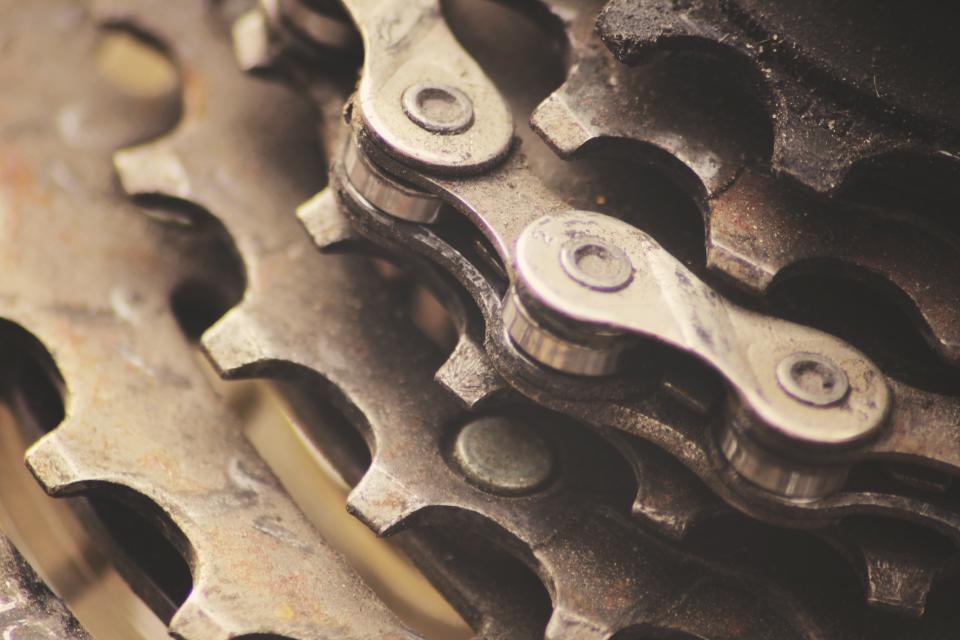 Close-up of a greasy chain running over the teeth of a rear cassette