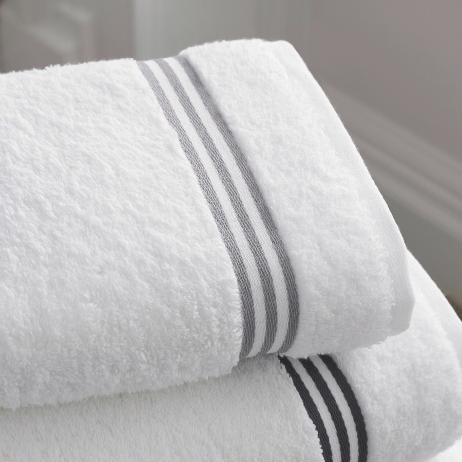 Two folded white bath towels with grey stripes