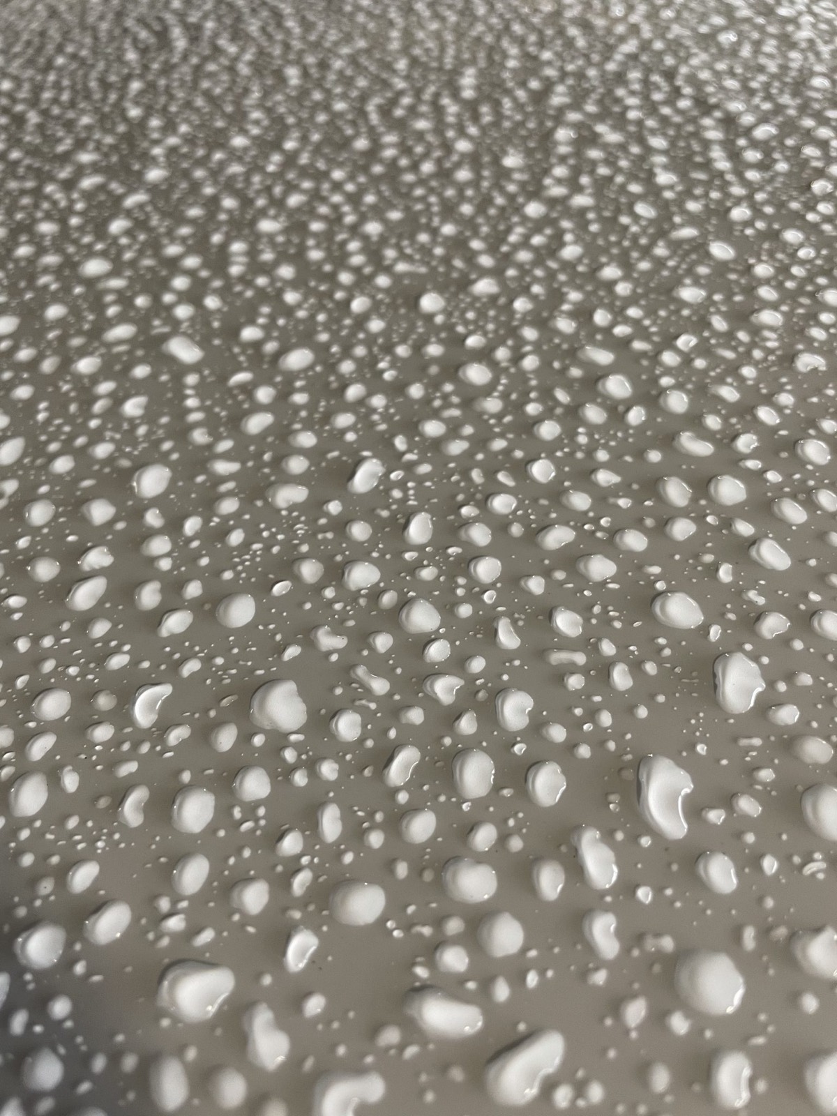 Close-up of water beading on a freshly coated car hood