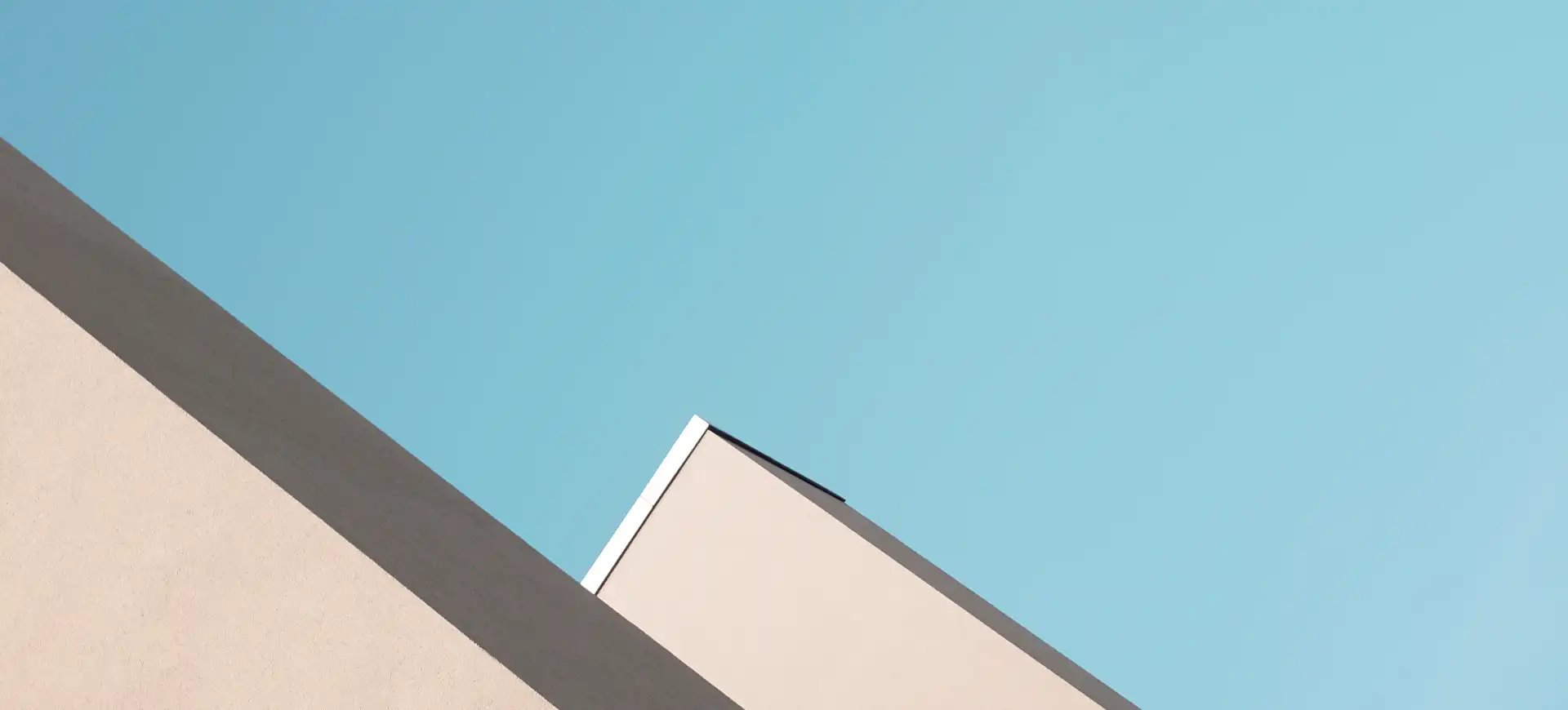 Two pale roof edges against a teal sky